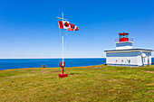 A quiet place with bench, Canadian national flag and lighthouse at the North-Atlantic ocean, Digby, Nova Scotia, Canada