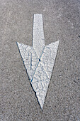 Weißer abgenutzter Hinweispfeil auf einer asphaltierten Straße, Naples, Florida, USA