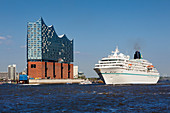 Cruise liner Amadea leaving at the harbour, view to the Elbphilharmonie, Hamburg, Germany