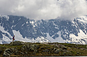 Girl trail running in Chamonix around the Chesery lake