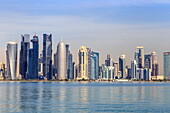 Modern city skyline of West Bay, across the calm waters of Doha Bay, from the Dhow Harbour, Doha, Qatar, Middle East