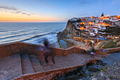 The soft colors of twilight frame the ocean and the village of Azenhas do Mar, Sintra, Portugal, Europe
