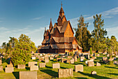 Heddal stave church with grave stones in the evening sun in summer, Notodden, Telemark, Norway, Scandinavia