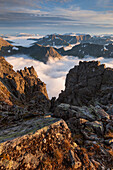 Blick vom Gipfel des Skårasalen auf die umliegenden Gipfel und die wolkenverhangenen Täler der Sunnmøre Alpen in der Abendsonne, Ålesund, Fylke Møre og Romsdal, Norwegen, Skandinavien