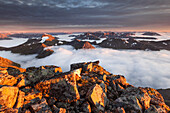 Blick vom Gipfel des Skårasalen auf die umliegenden Gipfel und die wolkenverhangenen Täler der Sunnmøre Alpen im letzten Abendlicht, Ålesund, Fylke Møre og Romsdal, Norwegen, Skandinavien