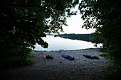 Drei Männer schlafen draußen nur mit Schlafsäcken an einem See, Freilassing, Bayern, Deutschland