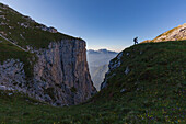 Hiker in silhouette near fork Besausega, Dolomites, Pale di San Lucano, Agordino, Belluno, Veneto, Italy, Europe