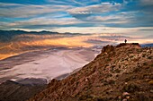 Tourist overlooking Panamint Mountains over Badwater Basin, from Dantes View, Death Valley National Park, California.