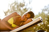 Woman lying down on sunlounger