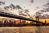 Manhattan Bridge at sunset (Brooklyn Bridge and Lower Manhattan skyline in background), New York, New York USA.