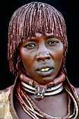 Hamer tribe woman with traditional necklaces and hear covered with a mixture of ochre and animal fat, Omo valley, Ethiopia, Africa.