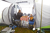 Mother sitting with son in a tent having breakfast