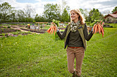 Woman in a garden holding carrotes