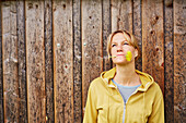 Woman with hawkbit in front of a wooden wall