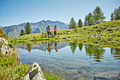 Couple biking in the mountains at lake
