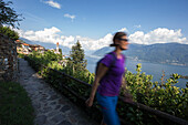Junge Wanderin geht durch eine alte Stadt, Ronco, Tessin, Schweiz