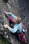 Young woman climbing at a rock face, Pottenstein, Franconia, Germany