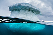 Above and below water view of the National Geographic Explorer, Brown Bluff, Antarctica.