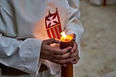Malaga: religious processions during the Holy Week. Penitents bearing candles. Spain
