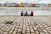 People group standing in riverside in front of Triana district. Seville, Andalusia, Spain.