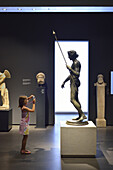 Rome. Italy. Child photographing a statue in the Museo Nazionale Romano. Palazzo Massimo alle Terme.