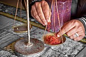 Dried saffron in a herbalist shop when weighing. Atlas Mountains region. Morocco.