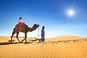 Tourist on camel ride, Erg Chebbi desert near Merzouga, Sahara, Morocco.