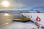 Small rowing boat used for fishing, sunk by the weight of snow, loch on Eaglesham Moor, near Glasgow, Scotland, UK. Image taken about 1 mile south of Eaglesham, Glasgow, Renfrewshire, Scotland overlooking Dunwan Dam , on the Eaglesham Moors, adjacent to t