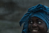 Einheimisches junges Mädchen steht hinter einem regenbedecktem Fenster, Sao Tome, Sao Tome und Príncipe, Afrika