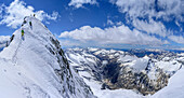Panorama with three persons back-country skiing descending from Care Alto, Presanella and Adamello group in background, Care Alto, Adamello group, Lombardia, Italy