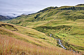 Lotheni River vor Berge in Wolken, Lotheni, Loteni, Mkhomazi Wilderness Area, Drakensberge, uKhahlamba-Drakensberg Park, UNESCO Welterbe Maloti-Drakensberg-Park, KwaZulu-Natal, Südafrika