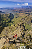 Woman climbing over ladder at Cathedral Peak, Cathedral Peak, Mlambonja Wilderness Area, Drakensberg, uKhahlamba-Drakensberg Park, UNESCO World Heritage Site Maloti-Drakensberg-Park, KwaZulu-Natal, South Africa
