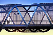 People passing by the Arganzuela bridge, designed by architect Dominique Perrault. Madrid Rio Park. Madrid. Spain.