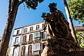 Figur of Maria in the garden of the cathedral, Santa Iglesia Catedral Basílica de la Encarnacion, with old houses in the background, Malaga, Andalusia, Spain