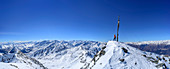 Panorama with woman back-country skiing standing at summit of Hasenoehrl, Brenta group, Presanella group, Ortler group and Oetztal Alps in background, Hasenoehrl, Ortler group, valley of Ultental, National Park Stilfser Joch, South Tyrol, Italy