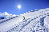 Woman downhill skiing from Sonnenjoch through deep snow in the back-country, Sonnenjoch, Kitzbuehel Alps, Tyrol, Austria