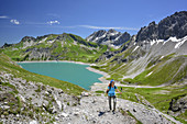 Frau beim Wandern mit Lünersee im Hintergrund, Lünersee, Rätikon-Höhenweg, Rätikon, Vorarlberg, Österreich