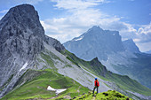 Woman hiking looking towards Kirchlispitzen, Drusenfluh and Drei Tuerme, Raetikon trail, Raetikon, Vorarlberg, Austria