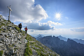 Woman and man descending from Ammergauer Hochplatte, Ammergauer Hochplatte, Ammergau Alps, East Allgaeu, Allgaeu, Swabia, Bavaria, Germany