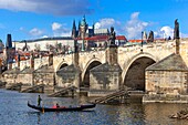 Venetian gondola on the river Vltava under Charles Bridge, Prague, Czech Republic.