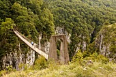Hiker walking on the footbridge, 180 metres over Gorges d´Holzarte, near Larrau village, Atlantics Pyrenees, in Aquitaine region France. Europe.
