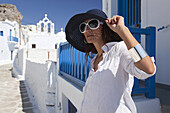 Frau posiert in Chora in der Nähe einer Kirche, Amorgos, Kykladeninseln, Griechische Inseln, Griechenland, Europa.