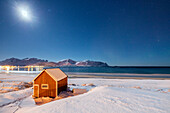 Moonlight on a typical fishermen cabin surrounded by snow, Ramberg, Flakstad, Nordland County, Lofoten Islands, Arctic, Norway, Scandinavia, Europe