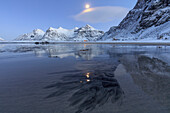 Full moon reflected in the icy sea around the surreal Skagsanden beach, Flakstad, Nordland county, Lofoten Islands, Arctic, Norway, Scandinavia, Europe