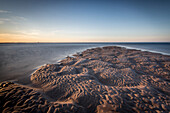 Sand formations at Budle Bay, with Holy Island Castle in the distance, Northumberland, England, United Kingdom, Europe