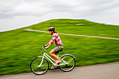 A woman rides her cruiser bike at Gasworks Park in Seattle, Washington on a cloudy day