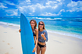 Couple of happy girls with surfboard