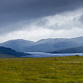 'Storm clouds and fog over the mountainous landscape and water in the Highlands; Scotland'