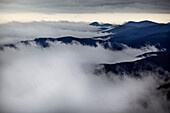 'Looking down on storm clouds moving up western North Carolina mountain valleys with the mountain tops and high ridges visible; North Carolina, United States of America'