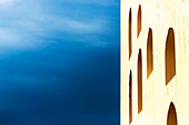 'A yellow wall with arched windows and a blue sky; Jaipur, Rajasthan, India'